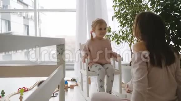 小女孩坐在摇椅上和妈妈玩视频的预览图