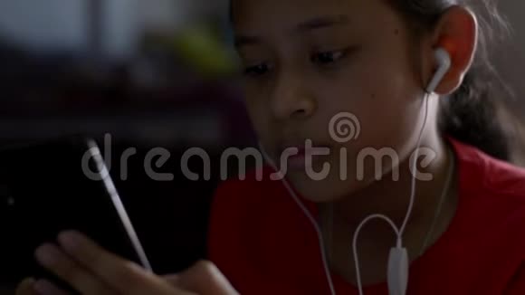 小女孩从手机里听音乐视频的预览图