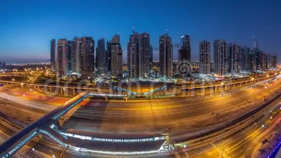 从空中俯瞰到迪拜码头附近的谢赫扎耶德路和JLT夜到白天迪拜视频的预览图