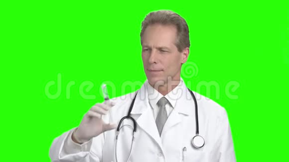 绿色屏幕上有注射器的男医生视频的预览图