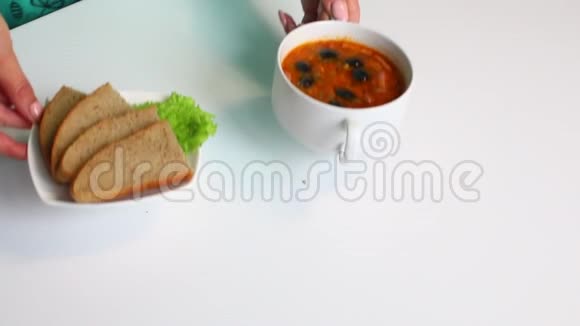 一个女人把一道现成的菜放在桌上汤咸汤烹饪的原料在桌子上视频的预览图