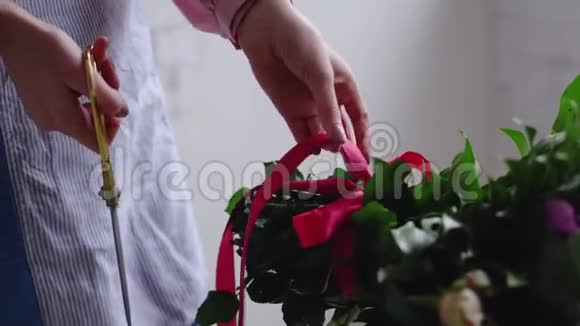 花匠用剪刀剪了花束上的红丝带视频的预览图