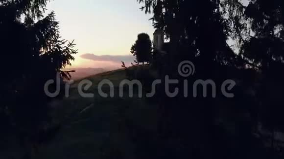 在山丘上拍摄的一个天主教堂的照片在日落的夏季可以看到村庄的美丽景色视频的预览图