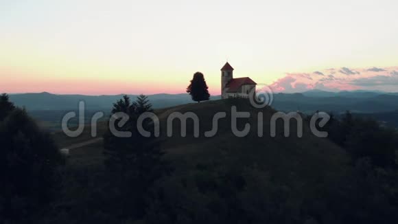 拍摄于一座山上的天主教堂在日落的夏日可以看到美丽的村庄景色视频的预览图