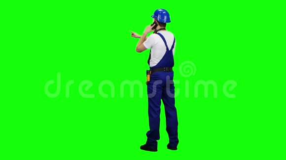 建设者站在他的背和电话绿色屏幕视频的预览图
