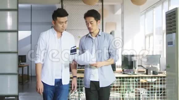 两位年轻的亚洲企业家在办公室讨论生意视频的预览图