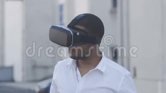 非洲裔美国青年穿着白色衬衫有虚拟现实头盔的经验VR眼镜商人视频的预览图