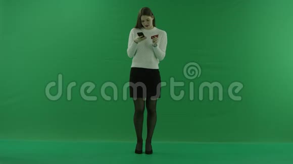 女孩从手机里的信用卡上输入数据然后在绿色屏幕上挥动她的手视频的预览图
