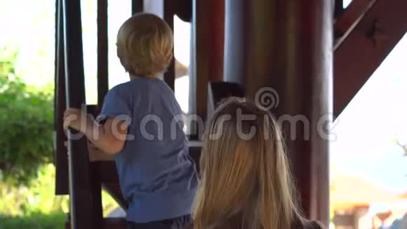 年轻女子和她的儿子走在伍登的楼梯上来到了Phu上的一座波德寺里的二楼视频的预览图