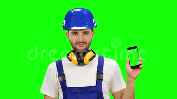 建设者手里拿着一部手机竖起大拇指绿色屏幕准备好了视频的预览图