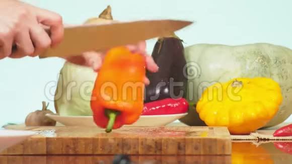女手用刀切橙椒蔬菜混合物用于烹饪蔬菜炖背景色视频的预览图