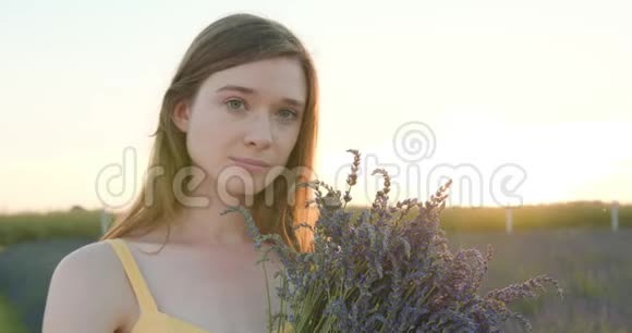 蓝色花朵领域的年轻女士视频的预览图