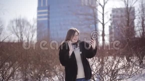 一位在冬季特大城市里视频聊天的旅游女性分享真实的旅游体验视频的预览图