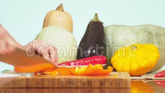 女手用刀切橙椒蔬菜混合物用于烹饪蔬菜炖背景色视频的预览图