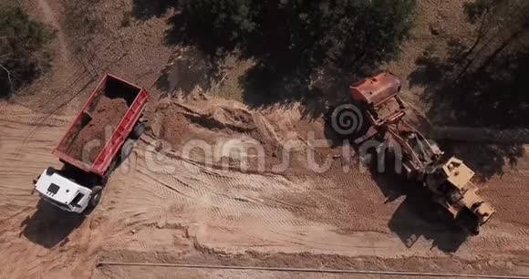 挖掘机将沙子装入卡车工人让路视频的预览图