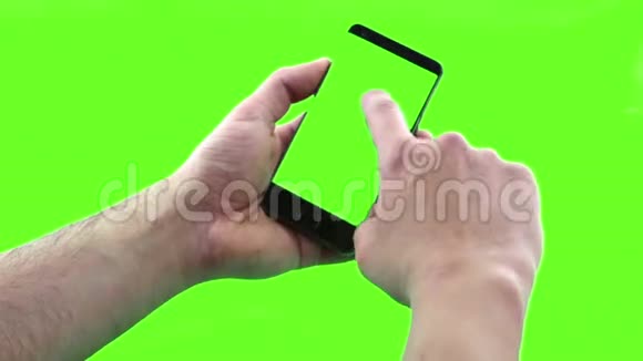 手持触摸屏设备用带有色度键的智能手机特写男性手背景绿色屏幕视频的预览图