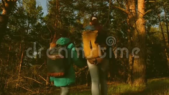 母女旅行者带着背包穿过树林在松林中的徒步旅行者游客喜欢视频的预览图