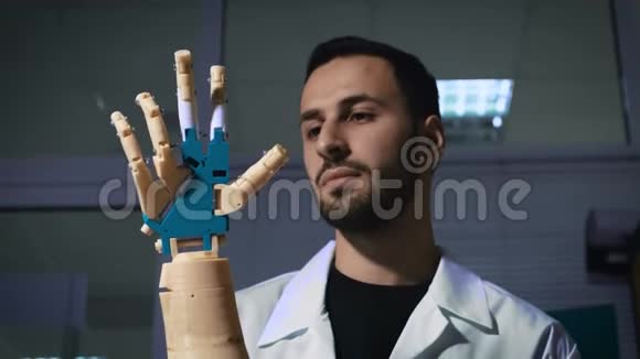 男性工程师科学家经历了机械手臂的仿生假体他看着机器人手的工作视频的预览图