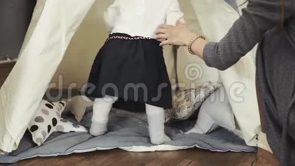 幼儿园里的白色帐篷和一个小女孩和她妈妈玩视频的预览图