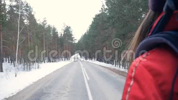 女人带着背包在美丽的冬天森林里徒步旅行斯坦迪卡姆视频的预览图