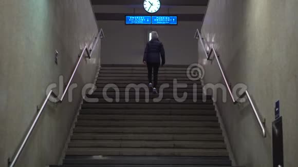 女孩爬上楼梯到火车站的站台视频的预览图