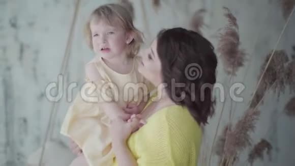 漂亮的孕妇和她的小女儿在房间里玩母亲得到了幸福因为她很快就会生育视频的预览图