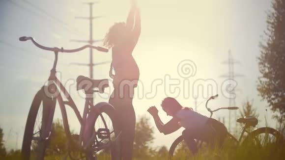 女孩们骑自行车的人互相照顾在帕克家取暖在她们的自行车旁边夏日的晴天视频的预览图