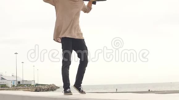 一个人肩上扛着滑板站在一边看视频的预览图