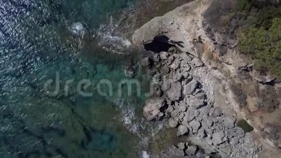 空中无人机镜头海浪溅起岩石追踪潮汐波的撞击当海浪飞溅时它们创造了一个视频的预览图