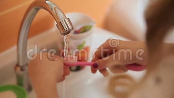 女孩把牙刷洗在水里视频的预览图