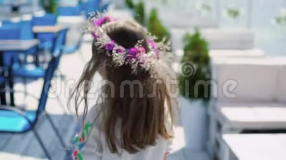 小聪明的女孩走着在酒吧的海湾上摆姿势带着花旋转慢慢地视频的预览图