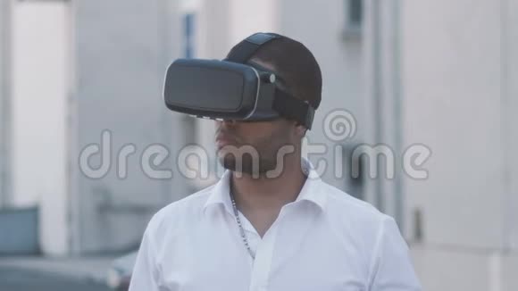 非洲裔美国青年穿着白色衬衫有虚拟现实头盔的经验VR眼镜商人视频的预览图