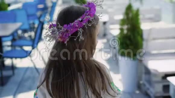 小女孩走着走着在酒吧的海湾上摆姿势带着花旋转慢慢地视频的预览图