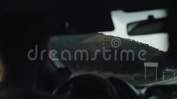 在蜿蜒的山路上驾驶汽车的司机的后视镜视频的预览图