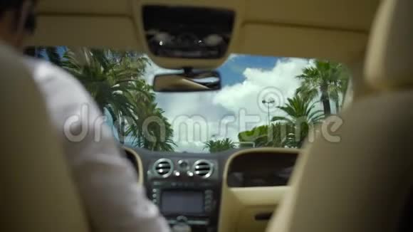 男子驾驶豪华车在度假城市暑假商务旅行视频的预览图