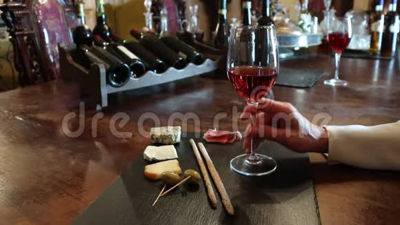 酒杯和奶酪盘葡萄酒测试验酒水晶杯红酒奶酪吧台背景视频的预览图