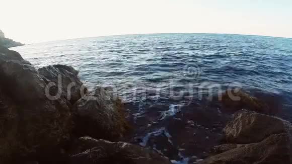 岩石海岸和海浪拍打岩石俯瞰开阔的大海视频的预览图