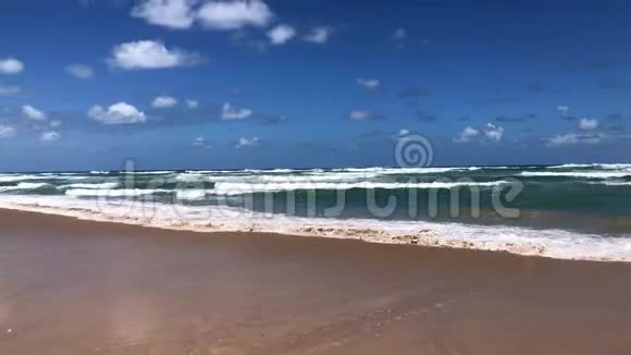 在有脚印的孤寂海滩上的海浪的鸟瞰视频的预览图