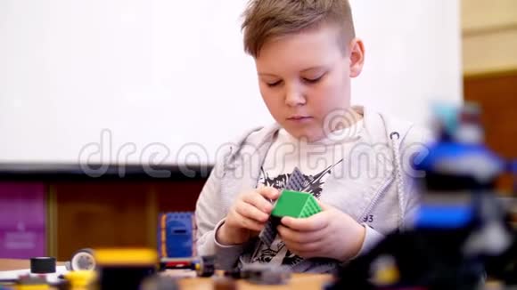这个11岁的男孩从立方体盘子电路电线中扮演设计师小发明家创造机器人视频的预览图