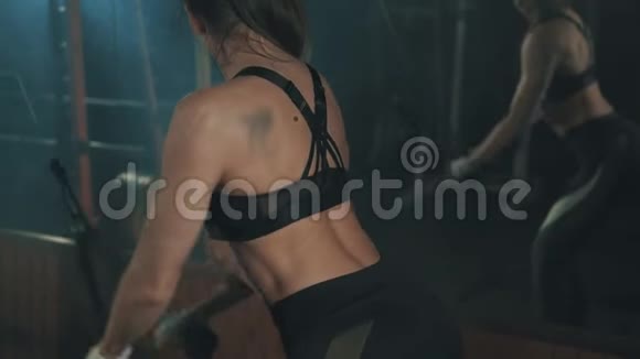 女子举重训练机在黑暗健身房慢动作训练视频的预览图