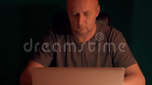 前视图员晚上在电脑上工作低键暗背景人在计算机上编码代码视频的预览图