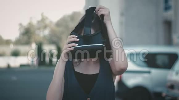 有吸引力的女人在街上用VR眼镜环顾四周的肖像穿着虚拟衣服的女孩变得与众不同视频的预览图