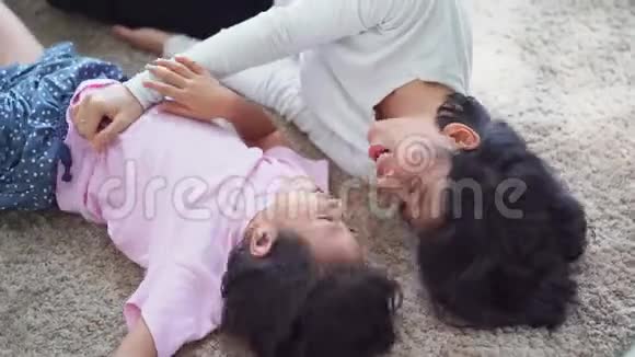 小女孩和她妈妈在地毯上开玩笑视频的预览图