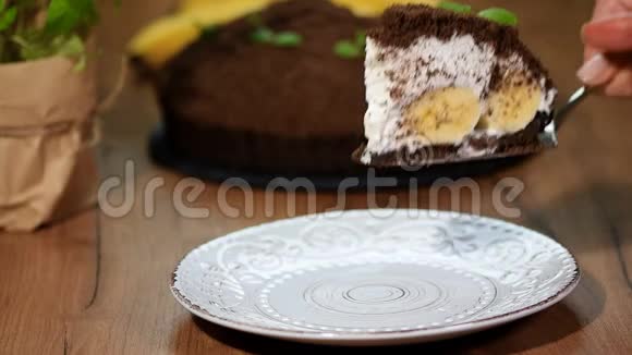 巧克力蛋糕加香蕉把一块蛋糕放进盘子里视频的预览图