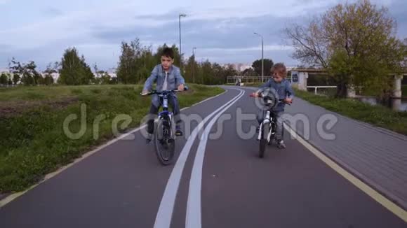 两个穿牛仔服装的白种人男孩骑自行车视频的预览图