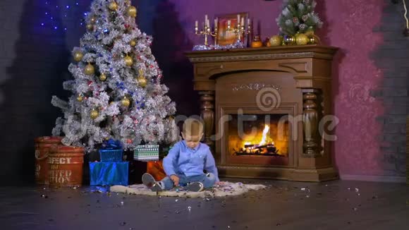 学龄前男孩在圣诞树附近玩玩具高清视频的预览图