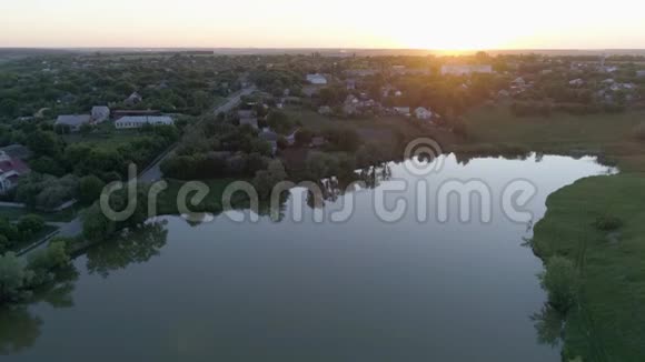 春天日落时分在湖边小镇上的鸟瞰图视频的预览图
