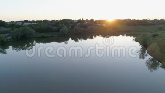 日落时的河流景观日落时的小镇后面的自然风光视频的预览图