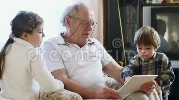 一位老人带着孙辈使用平板电脑视频的预览图