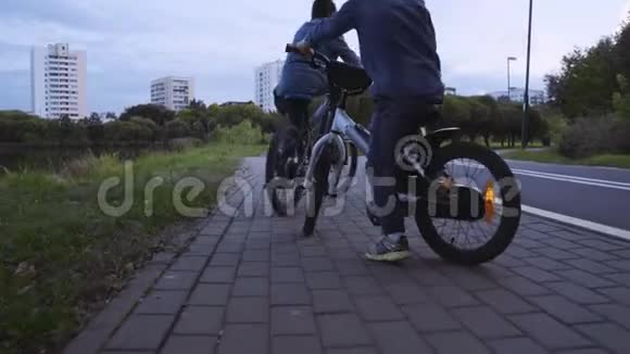 两个穿牛仔服装的白种人男孩骑自行车视频的预览图